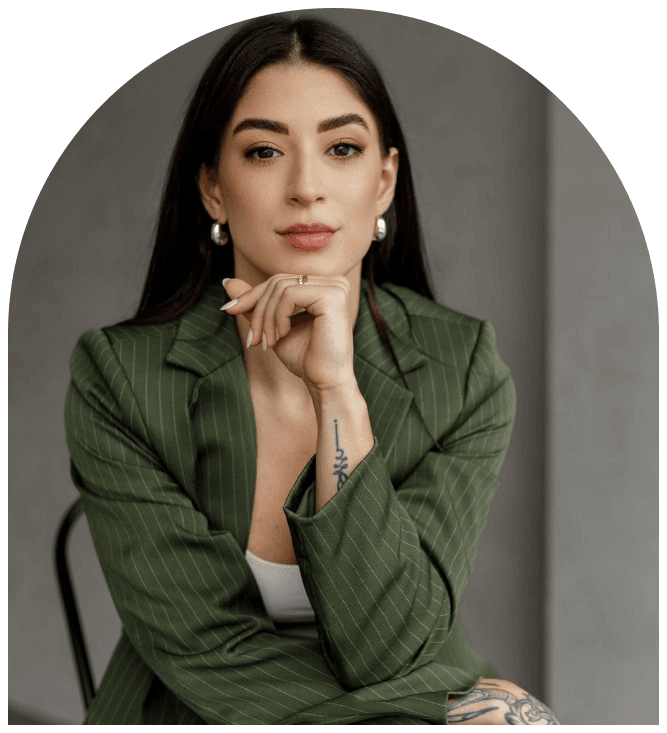 Amanda Teruel, nutricionista em Curitiba, sentada e sorrindo, vestindo blazer verde